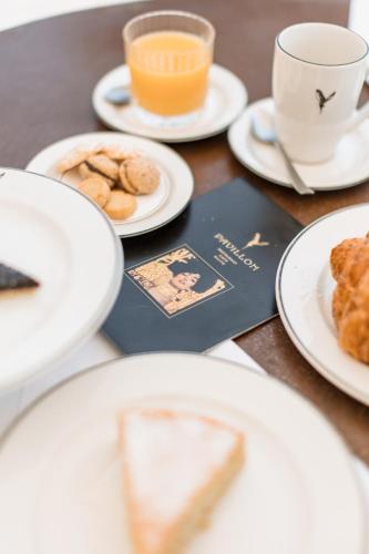 a table with plates of food and a cup of coffee at Pavillon Apartments in Peschiera del Garda