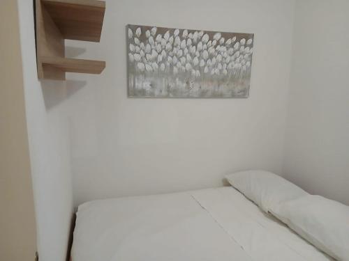 a white room with a bed and a picture on the wall at Apartments Brčić in Sveti Petar