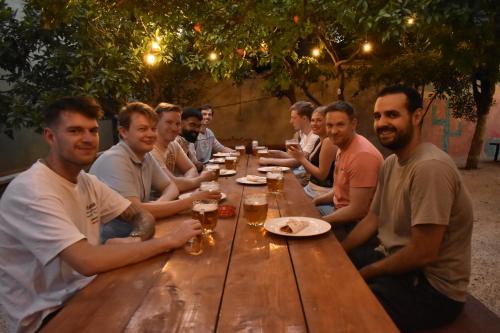 a group of men sitting around a wooden table at Trip'n'Hostel Pink Bubble in Tirana