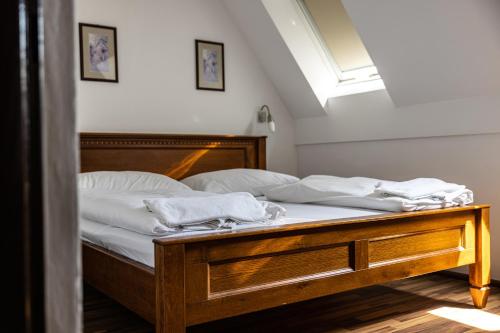 a bedroom with a bed with white sheets and a window at Penzion Royal in Trenčín