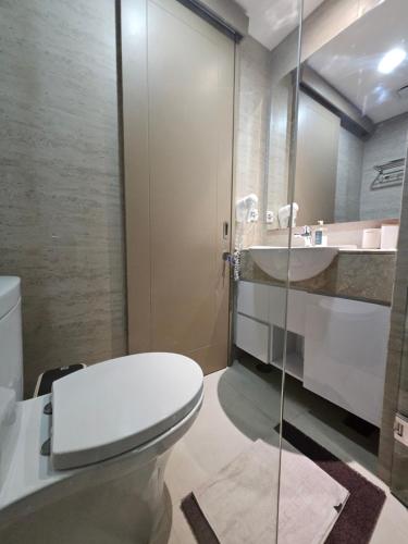 a bathroom with a toilet and a sink at Apartemen Oakwood honolulu in Jakarta