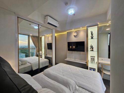 a bedroom with two beds and a mirror at Apartemen Oakwood honolulu in Jakarta
