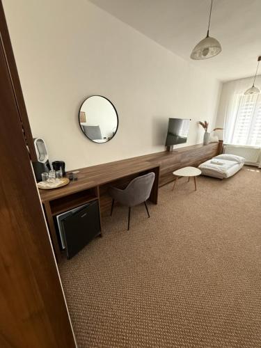 a living room with a desk and a mirror at Penzión Max Kežmarok in Kežmarok