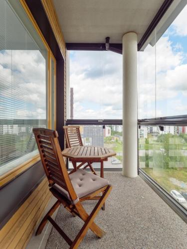 two chairs and a table on a balcony with windows at Avara huoneisto Verkatehtaan vieressä in Hämeenlinna