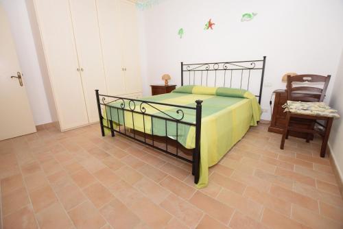 a bedroom with a bed and a table and a chair at Bilocale Mancini 4 in Lacona