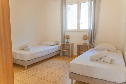 Cette chambre comprend 2 lits et une fenêtre. dans l'établissement Villa Ile d'Eden - Vue mer-Piscine - By Sister Home, à Sainte-Marie