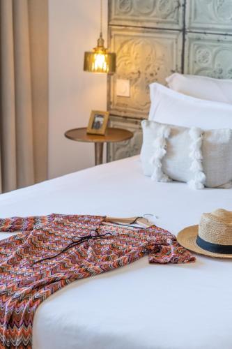 a hat sitting on the edge of a bed at Résidence Casarina in Bonifacio