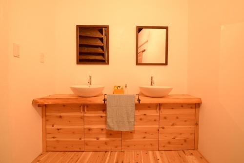 baño con 2 lavabos en la parte superior de una barra de madera en Hakone Guesthouse Toi, en Hakone