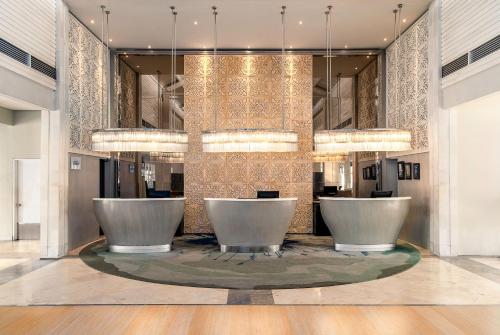 una hall con due sedie bianche in un edificio di Sheraton Bandung Hotel & Towers a Bandung