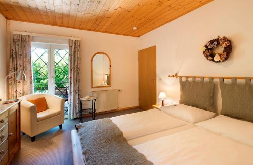 a bedroom with a bed and a chair in it at Appartements im Park in Krumpendorf am Wörthersee