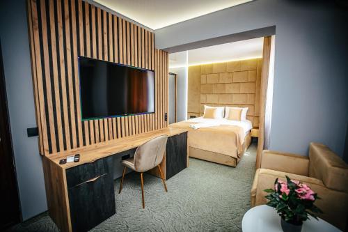 a hotel room with a bed and a flat screen tv at Fit Residence III in Cluj-Napoca