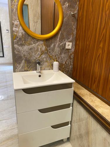 ein Badezimmer mit einem weißen Waschbecken und einem Spiegel in der Unterkunft Amar House 2 in Yerevan