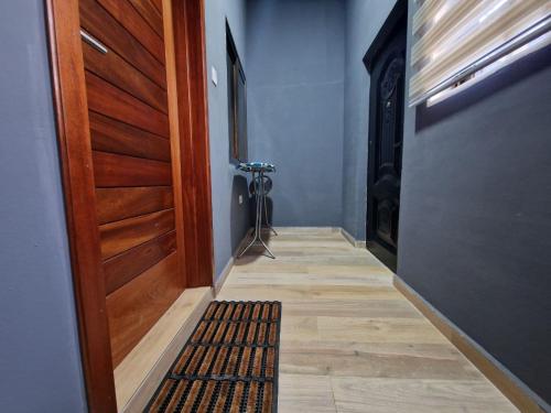 a hallway with a wooden door and a rug at Kirpal Villa in Kwabenya