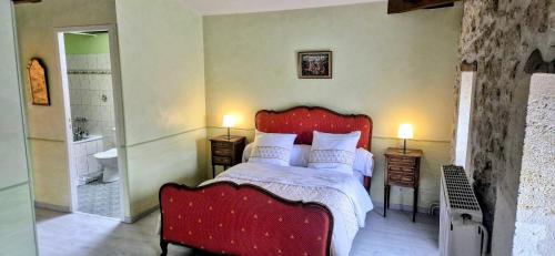 - une chambre avec un lit rouge et une salle de bains dans l'établissement La Résidence du Vignoble L'Homme Cheval, à Anglade