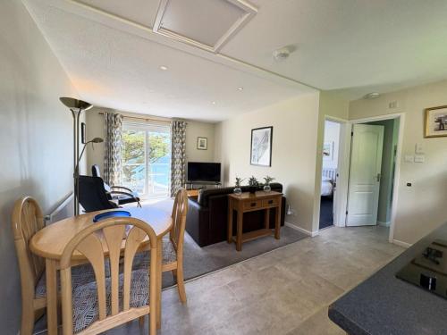 a living room with a table and a couch at Trevian - Mount Brioni in Downderry