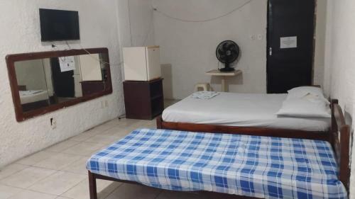 a small room with a bed and a mirror at HOTEL LIVRAMENTO Maceió in Maceió