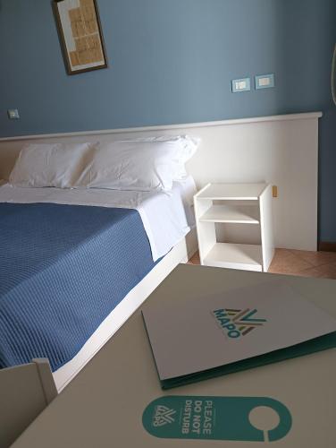 a bedroom with a bed with a blue wall at Hotel Club Perla in Casalabate