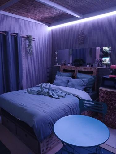 a bedroom with a bed and a white table at Le doux refuge in Le Mont-Dore