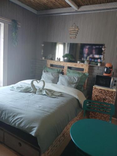 a bedroom with a large bed with a blue table at Le doux refuge in Le Mont-Dore