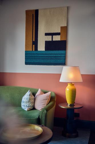 a living room with a green couch and a lamp at The July - Boat & Co in Amsterdam