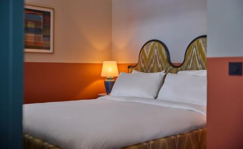 a bed with white sheets and a lamp in a room at The July - Boat & Co in Amsterdam