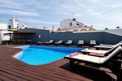 a swimming pool with chaise lounges and chairs on a deck at KR Hotels - Albufeira Lounge in Albufeira