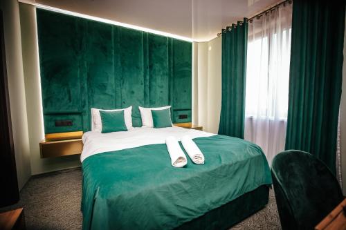 a hotel room with a bed with slippers on it at Fit Residence III in Cluj-Napoca