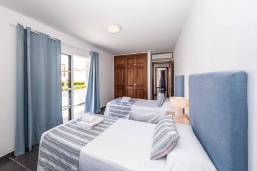 a hotel room with two beds and a window at Villa Carolina in Alaior