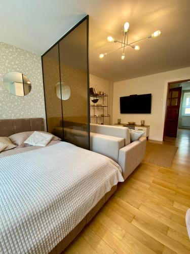 a bedroom with a large white bed and a television at Apartamenty na Klasztornej in Jasło