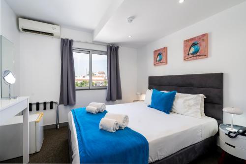 a bedroom with a large bed and a window at KR Hotels - Albufeira Lounge in Albufeira