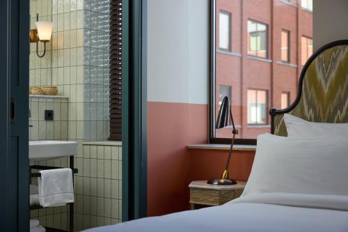 a bedroom with a bed and a sink and a window at The July - Boat & Co in Amsterdam