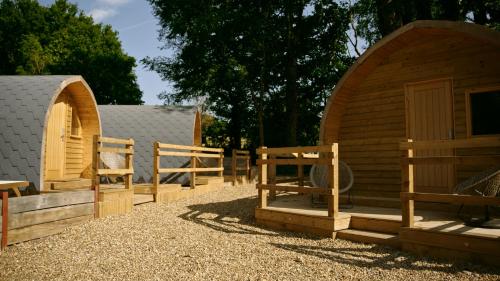 a wooden cabin with a gate and a fence at Forrester Park Glamping Pods - Eagle Pod and Birdie Pods in Great Totham