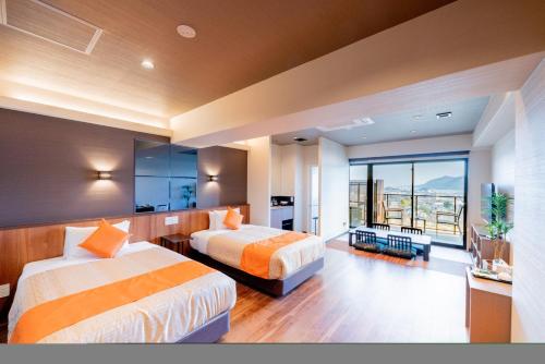 a hotel room with two beds and a balcony at LiVEMAX RESORT Miyahama Ocean View in Hatsukaichi