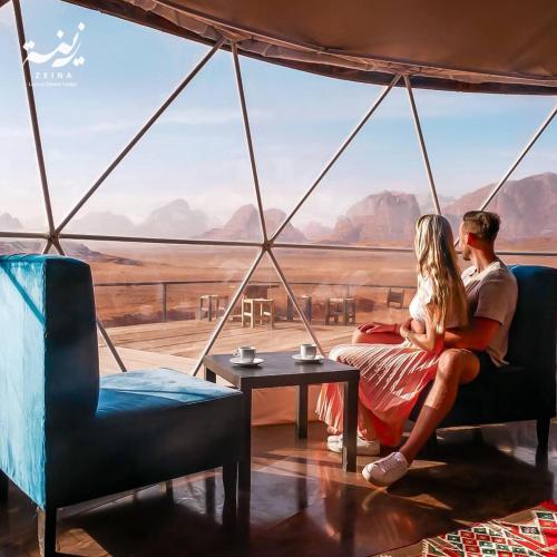 a couple sitting in a tent with a view of the desert at Zeina Desert Lodge in Wadi Rum