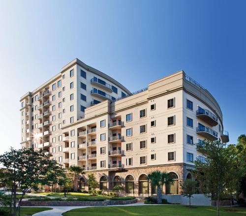 a large white building with trees in front of it at Wyndham La Cascada 2BR Apartment with Resort Access in San Antonio