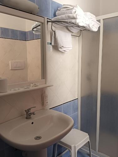a bathroom with a sink and a mirror and a shower at Hotel Club Perla in Casalabate
