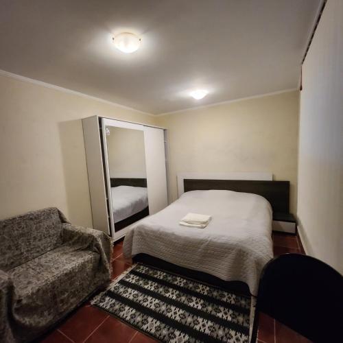 a bedroom with a bed and a chair and a mirror at Hotel Nike in Tsalka