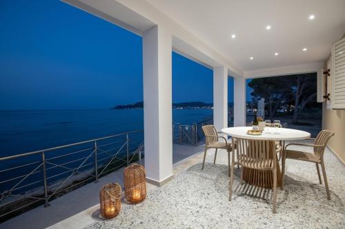 un tavolo bianco e sedie su un balcone con vista sull'oceano di Athinas beach house a Alykes