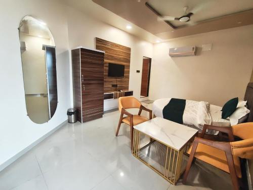 a living room with a couch and a table at Marco luxury hotel in Anand
