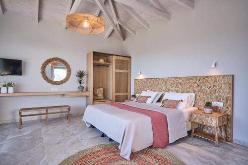 a bedroom with a large bed and a mirror at Asteris Hotel in Skala Kefalonias