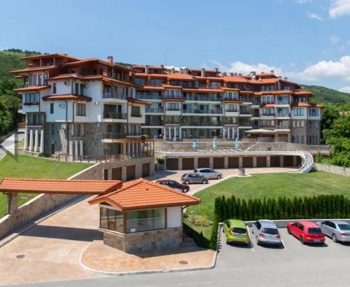 a large apartment building with cars parked in a parking lot at Nikol Apart in Balchik