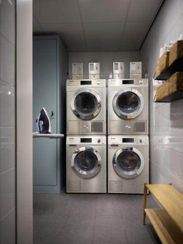 a laundry room with three washer and dryer at The July - Boat & Co in Amsterdam