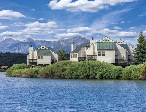 a row of houses on the shore of a lake at Wyndham Pagosa Springs 2BR Apartment with Resort Access in Pagosa Springs