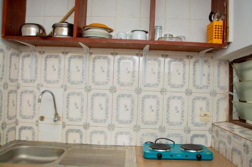 una cucina con una stufa giocattolo blu sul bancone di studio CHEZ VOUS a Lomé