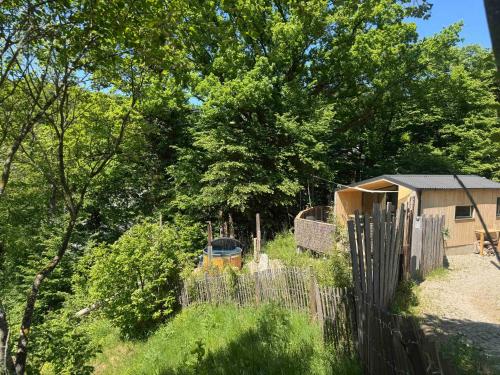 a fence in front of a yard with trees at Domaine des Constellations - Tiny Houses & Bains Nordiques in Orbey