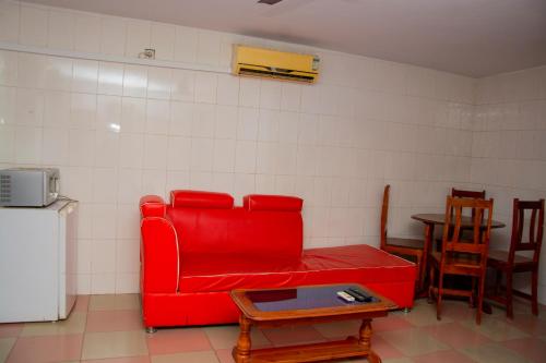 un soggiorno con un divano rosso e un tavolo di studio CHEZ VOUS a Lomé