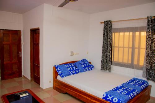 una camera da letto con un letto con cuscini blu di studio CHEZ VOUS a Lomé