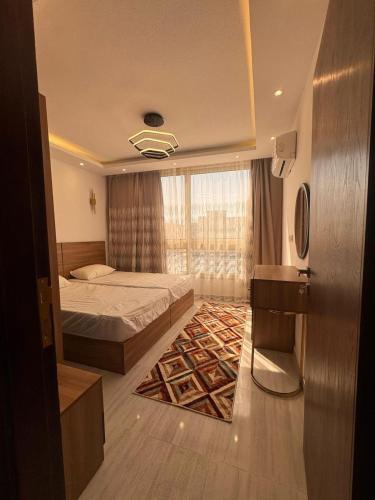 a bedroom with a bed and a large window at Avenuo apartment in Hurghada