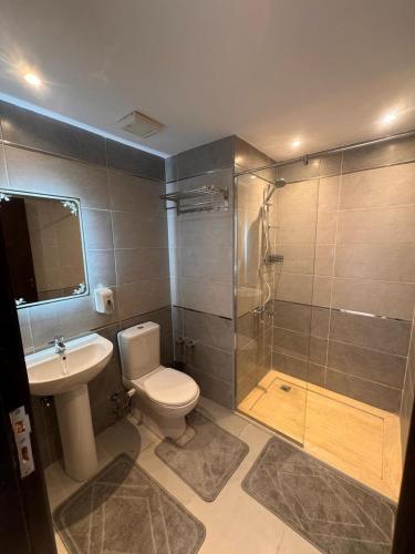 a bathroom with a toilet and a sink and a shower at Avenuo apartment in Hurghada