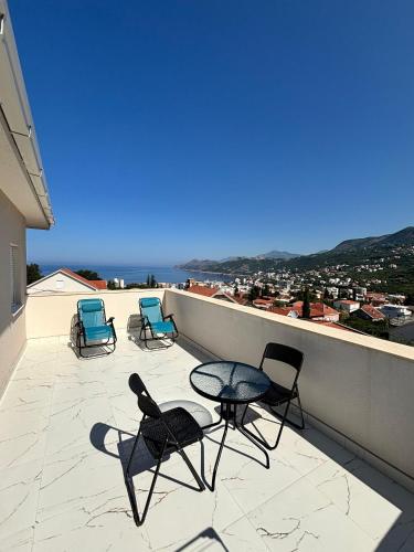 three chairs and a table on a balcony with a view at Apartmani Kula in Pečurice